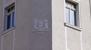 Das Wappen an der Fassade verweist auf die ehemlalige Bürgermeisterei