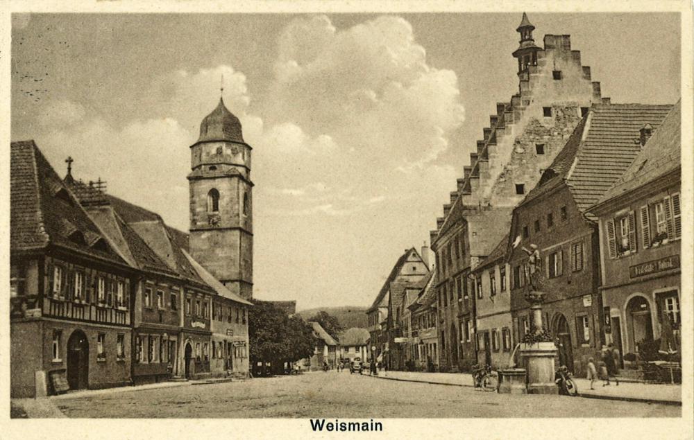 Abb. 2: Blick über den Marktplatz von Weismain in den 1920er Jahren: Links ragt die Pfarrkirche auf, rechts (mit seiner treppenartigen Dacheinsäumung) erkennt man das Rathaus, davor den Rolandsbrunnen