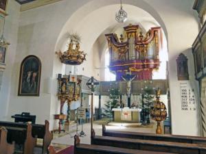 Abb. 34: Blick zum Altar mit darüber angeordneter Orgel, seitlicher Kanzel (l.), Taufstein (r.) und Gemälden an den Emporen (o. r.)