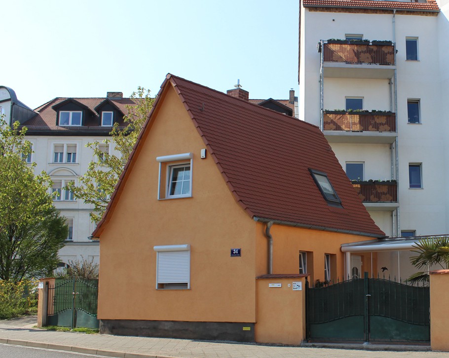 Beispiel für ein ehemals kleinbäuerliches Wohnhaus, dahinter moderne Mietshäuser