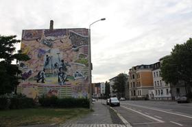 Graffiti in der Georg-Schumann-Straße 25 im Rahmen des sachsenweiten Projektes 'Untold Stories' zum 25. Jahrestag der Friedlichen Revolution. Das Grafiiti erzählt die Geschichte einer Gruppe von Schülern, die 1989 mit einer Plakataktion in ihrer Schule im Leipziger Norden ihre Mitschüler auffordern wollten, sich an den Demonstrationen gegen das DDR-Regime zu beteiligen.