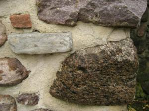 Abb. 15: Rechts in der unteren Hälfte befindet sich der im Text beschriebene Kristinehamn-Granit. Der helle Stein links oberhalb ist ein Kalkstein, die sonst eher selten in der Stadtmauer zu finden sind. Am oberen Bildrand ist wieder ein jotnischer Sandstein zu sehen.